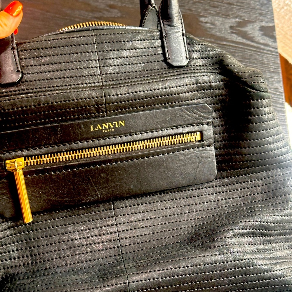 Black leather with gold trim Lavin bag. Can wear cross body or on shoulder.